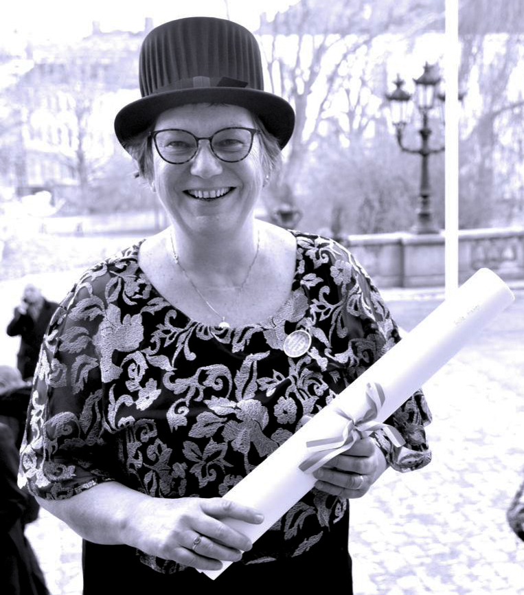 Hille Haker holds her honorary doctorate degree on the steps outside of Uppsala University