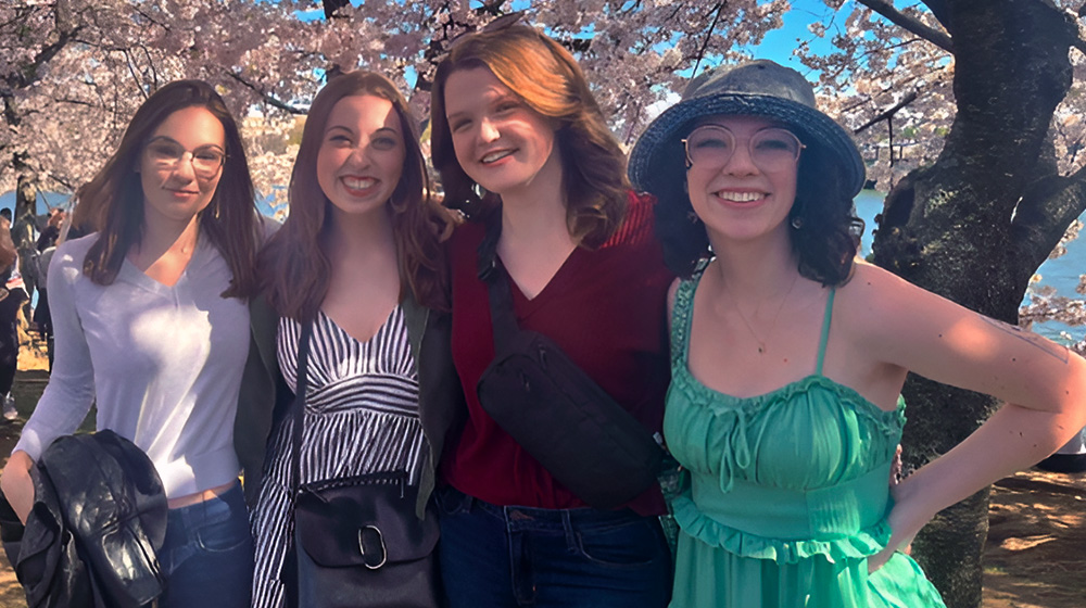 Loyola students pose under the blooming cherry blossom trees