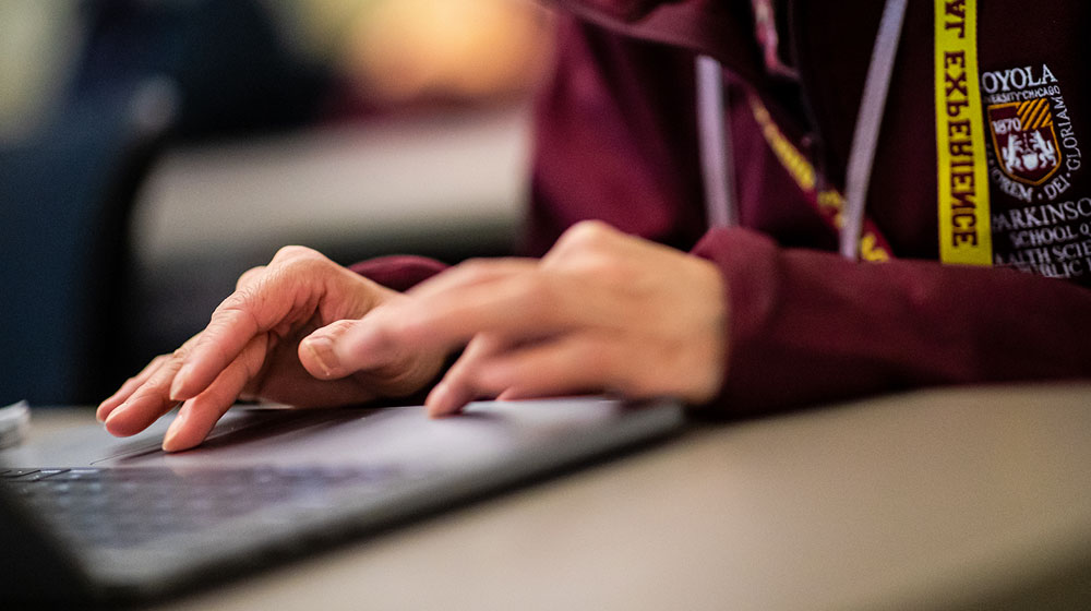 A laptop is the focus point as a Health Science Campus staff member uses it to aid in their event.