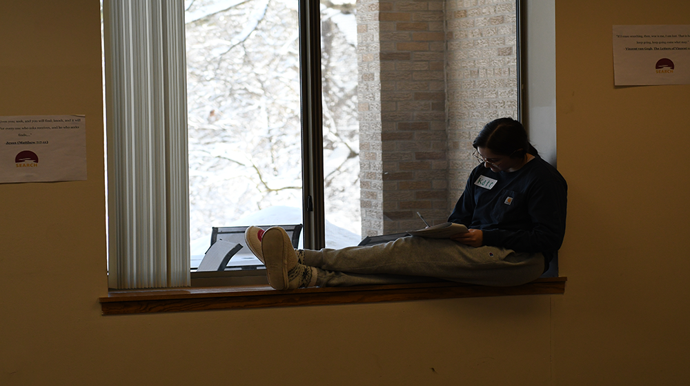 Student by window, writing