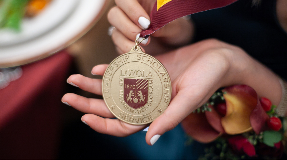 A student showcases the medallion they earned for their accomplishments.