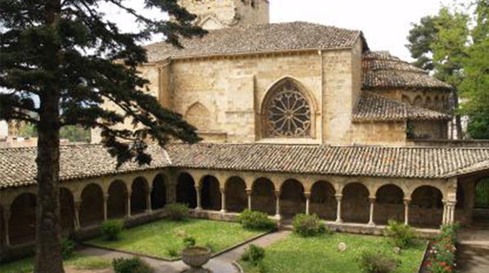 Aerial view of a medieval building made of stone with a grass courtyard.