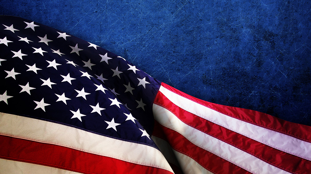 American flag flowing over a blue background.